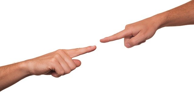 One partner pointing accusingly at the other during an argument